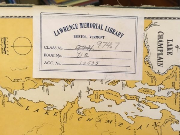 end paper of a book showing lake Champlain with a checkout card stuck on top of it